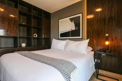 a bedroom with a white bed with wooden walls at Morada by Wynwood House in Lima