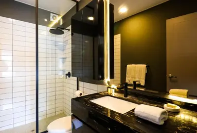a bathroom with a sink and a toilet and a mirror at Morada by Wynwood House in Lima