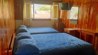 a bedroom with two beds and a window at Hospedaje Olguita in Oxapampa
