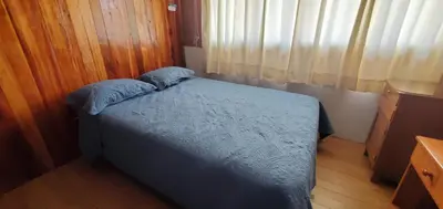 a bedroom with a bed with blue sheets and pillows at Hospedaje Olguita in Oxapampa