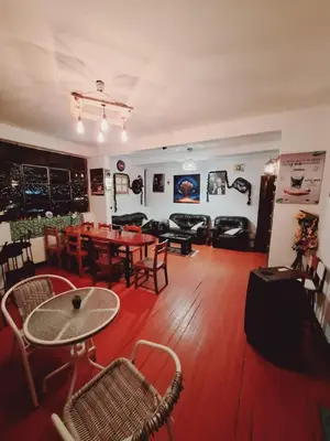 a restaurant with wooden floors and tables and chairs at Antis Apartment in Cusco
