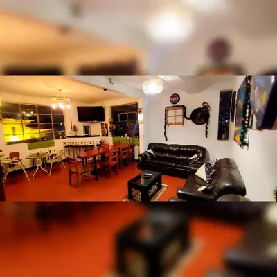 a living room with a couch and a dining room at Antis Apartment in Cusco