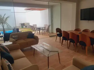 a living room with a couch and a table and chairs at Hermosa Casa de Playa km 90.5 in Bujama Baja