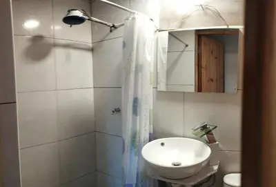 a bathroom with a sink and a toilet and a shower at Fachwerkhaus zum Hirsch in Oxapampa