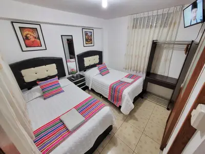 a bedroom with two beds and a window at Hostal EL VIAJERO en Ollantaytambo in Ollantaytambo