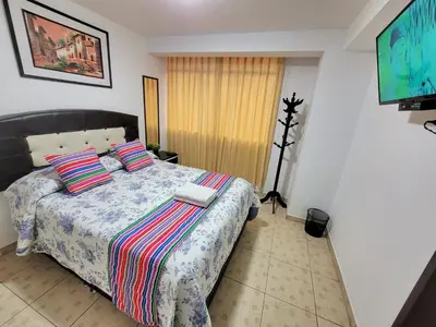 a bedroom with a bed with two pillows and a television at Hostal EL VIAJERO en Ollantaytambo in Ollantaytambo