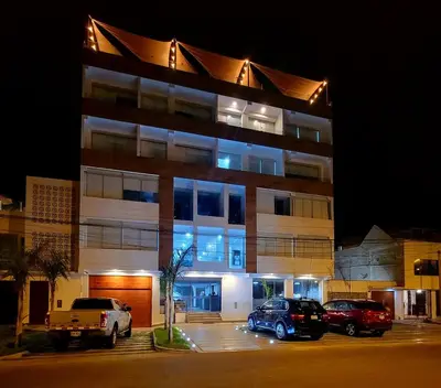 a large building with cars parked in a parking lot at ALTEA HOTEL - San Bartolo in San Bartolo