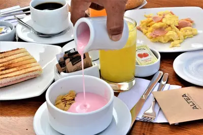 a person pouring a drink into a bowl of food at ALTEA HOTEL - San Bartolo in San Bartolo