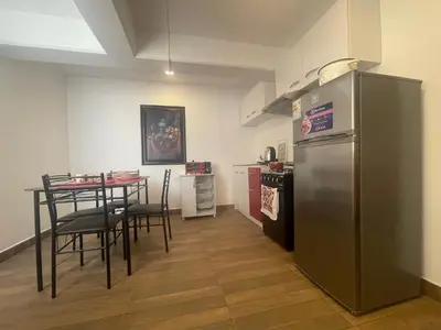 a kitchen with a table and a stainless steel refrigerator at (21) Depto. nuevo y acogedor en Miraflores in Lima