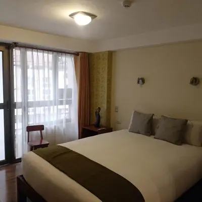 a bedroom with a large bed and a window at Hotel Pucara Machupicchu in Machu Picchu