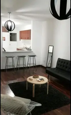 a living room with a black couch and a table at Pacific Spot San Miguel in Lima