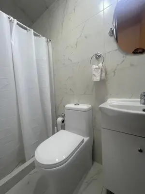 a white bathroom with a toilet and a sink at 23 Dpto de Estreno Miraflores in Lima