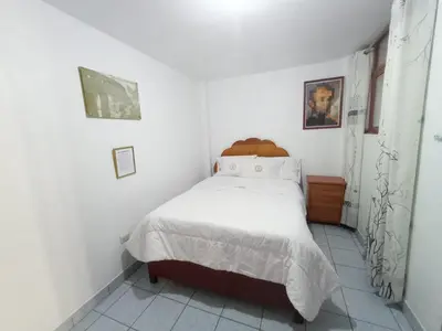 a bedroom with a bed in a white room at Hotel MESONERO in Ayacucho