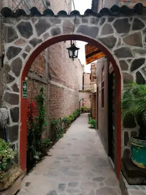 an alley with an archway in a stone building at Hotel MESONERO in Ayacucho