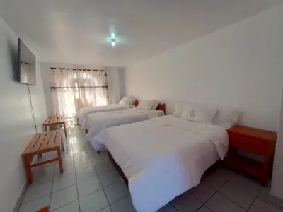 a hotel room with two beds and a television at Hotel MESONERO in Ayacucho