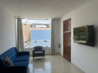 a living room with a blue couch and a window at MH Apartments Ica 2 in Ica