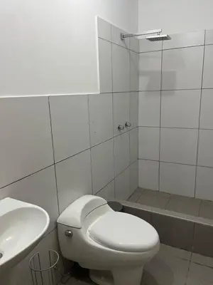 a white bathroom with a toilet and a sink at MH Apartments Ica 2 in Ica
