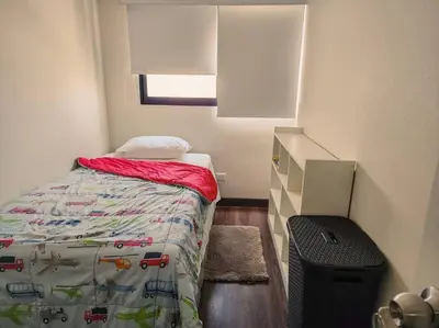 a small bedroom with a bed with a comforter on it at San Miguel Exclusivo Depa Vista al Mar, piscina in Lima