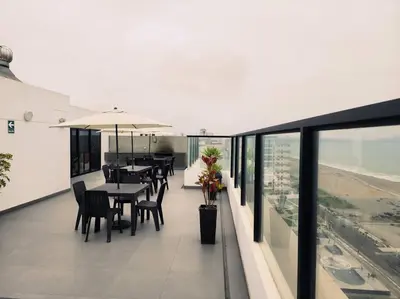 a dining room with tables and chairs on a balcony at San Miguel Exclusivo Depa Vista al Mar, piscina in Lima