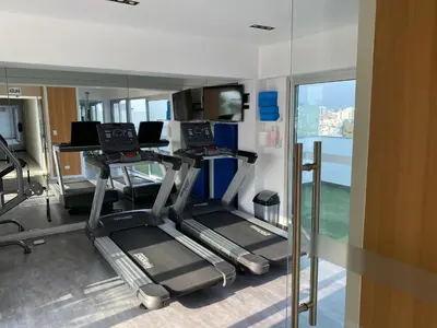 a gym with two treadmills and a window at Moderno departamento Miraflores 360 in Lima