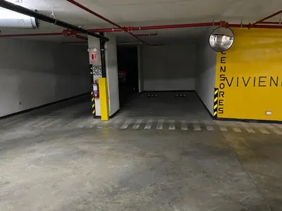 an empty parking garage with a yellow sign on the wall at Moderno departamento Miraflores 360 in Lima