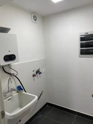 a white bathroom with a sink and a fan at Moderno departamento Miraflores 360 in Lima