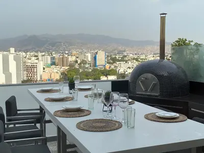 a white table with wine glasses and a pizza oven at Moderno departamento Miraflores 360 in Lima