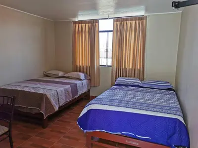 a bedroom with two beds and a window at Catalina Huanca Resort in San Jerónimo