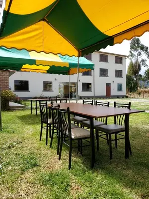 a group of tables and chairs with umbrellas at Catalina Huanca Resort in San Jerónimo
