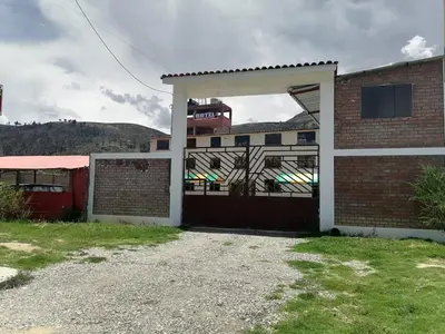a house with a garage with a brick building at Catalina Huanca Resort in San Jerónimo