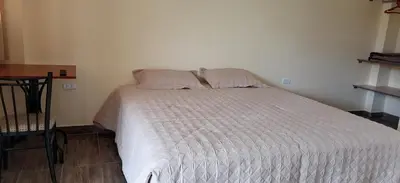 a bedroom with a white bed with two pillows at Catalina Huanca Resort in San Jerónimo