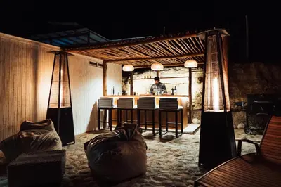 a man standing in front of a bar in a room at Atenas Hotel Boutique in Paracas