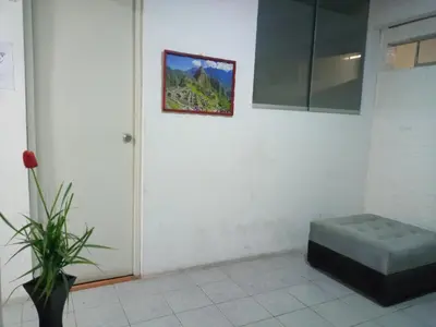 a room with a chair and a picture on the wall at Mochileros in Lima