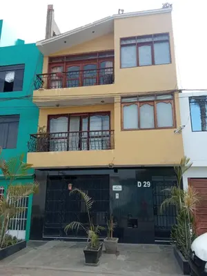 a large yellow building with a balcony at Mochileros in Lima