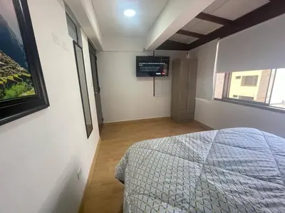 a bedroom with a bed and a tv on the wall at (28) Acogedor dpto. Miraflores in Lima