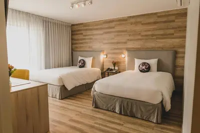 two beds in a hotel room with wooden walls at ARTE HOTEL Lima in Lima