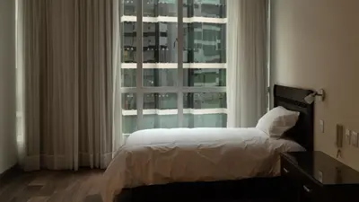 a bedroom with a bed and a large window at LIMA HOST in Lima