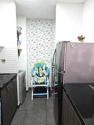 a kitchen with a chair next to a refrigerator at Dpto acogedor con terraza privada in Lima