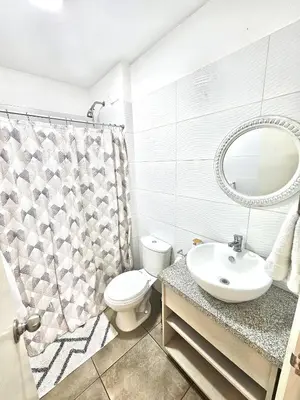 a bathroom with a toilet and a sink and a mirror at Dpto acogedor con terraza privada in Lima