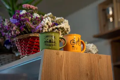 two coffee mugs sitting on a table with a basket of flowers at Casa Antade Cusco in Cusco