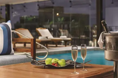 a tray of fruit and wine glasses on a table next to a pool at DoubleTree by Hilton Lima Miraflores El Pardo in Lima
