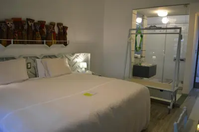 a bedroom with a large white bed and a mirror at Collacocha B&B in Lima