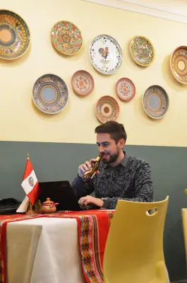 a man playing a saxophone next to a table with a laptop at Collacocha B&B in Lima
