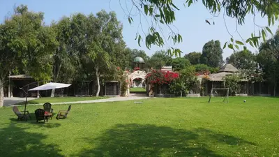 a yard with chairs and an umbrella and a building at Darenas Hacienda in Aucallama