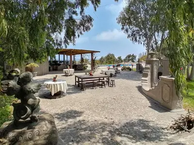 a patio with tables and chairs and a pavilion at Darenas Hacienda in Aucallama