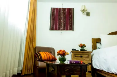 a bedroom with a bed and a chair and a table at Casa San Blas Cusco Boutique Hotel in Cusco