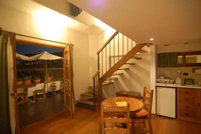 a kitchen and dining room with a table and a staircase at Casa San Blas Cusco Boutique Hotel in Cusco