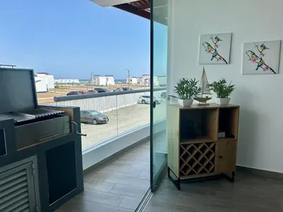 a living room with a fireplace and a view of a street at Moderno Departamento con Piscina y Parrilla, 3 min de la playa, Asia in Asia