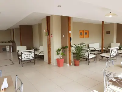 an empty waiting room with chairs and tables at Hotel Las Palmas in Lima
