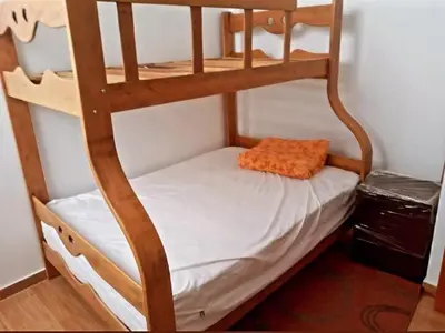 a bunk bed with an orange pillow on the bottom bunk at CASITA PARA FIN DE SEMANA in Rancho Cesar